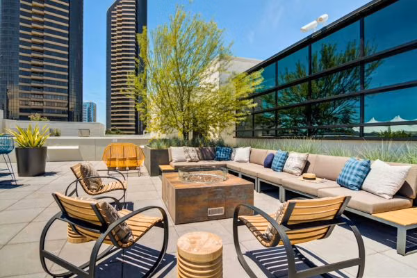Rooftop lounge with firepit and downtown skyline views at 4th and J